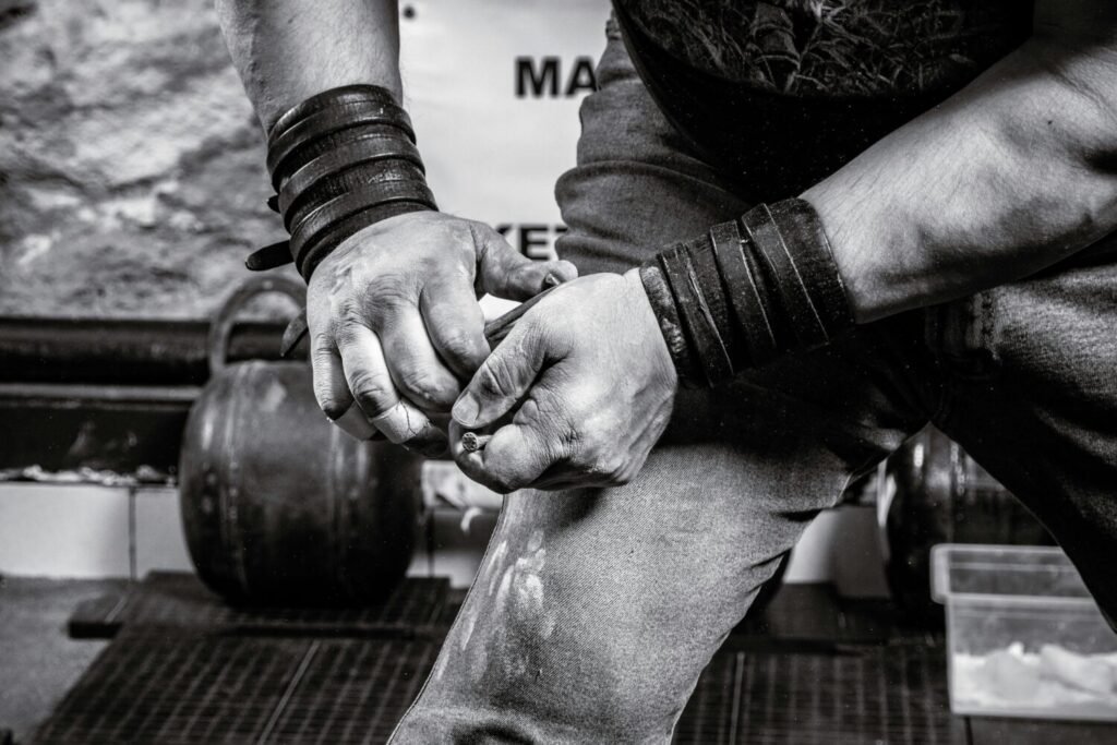 Close-up of a muscular athlete's hands chalked and ready to lift weights.