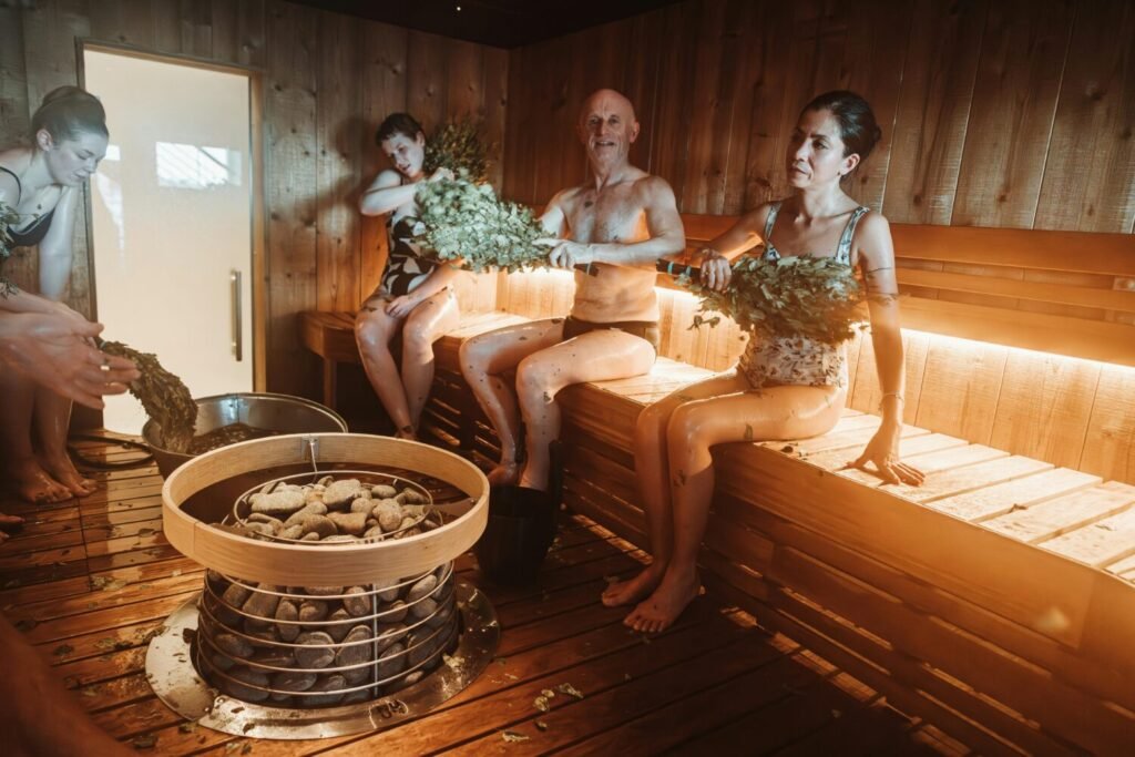 Group of people enjoying a traditional Nordic sauna with natural sauna whisking.