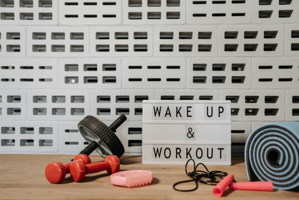 Fitness gear and motivational sign in home gym setup against a brick wall.